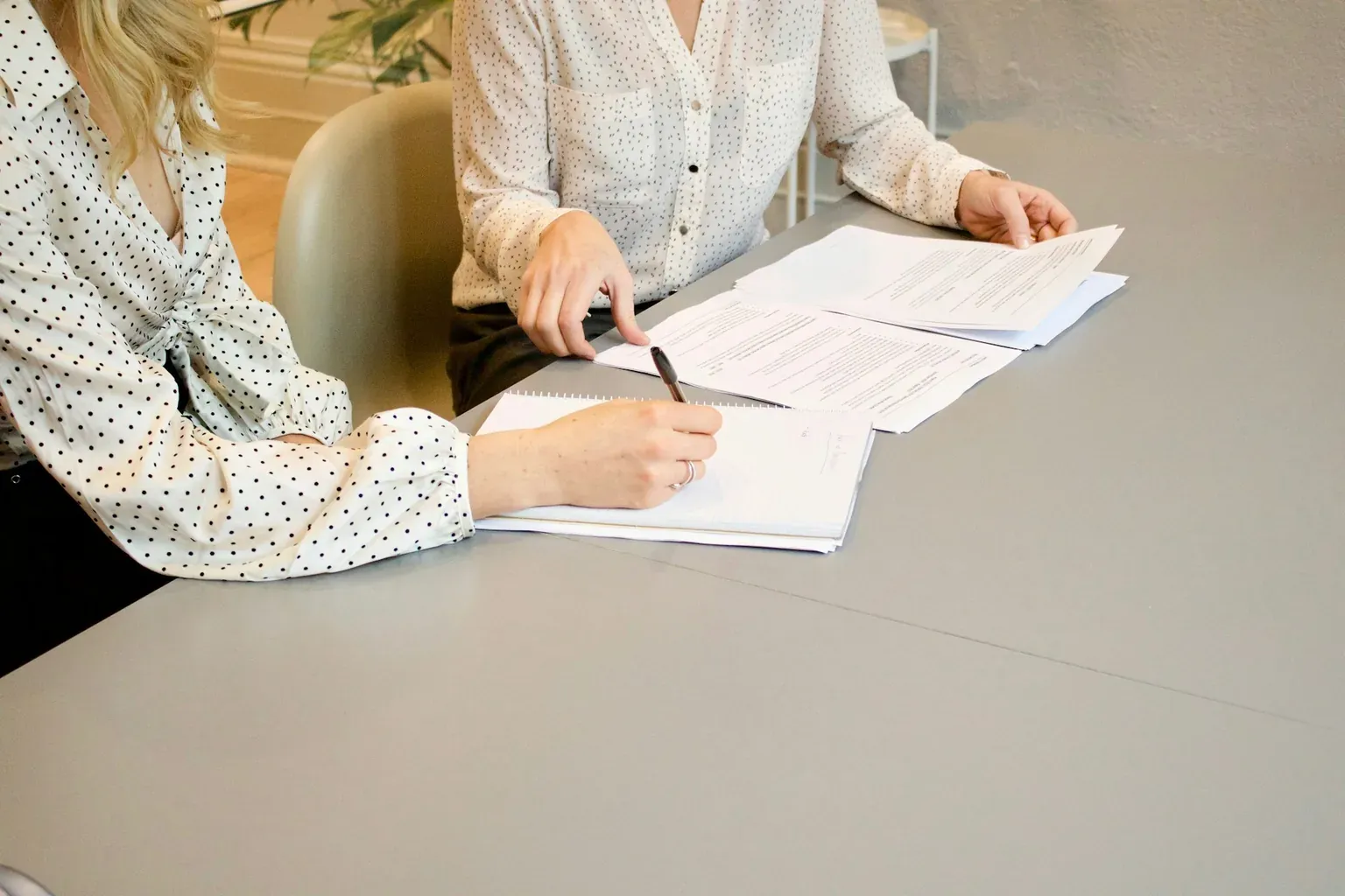 Deux personnes examinant ensemble un rapport lors d’un rendez-vous client